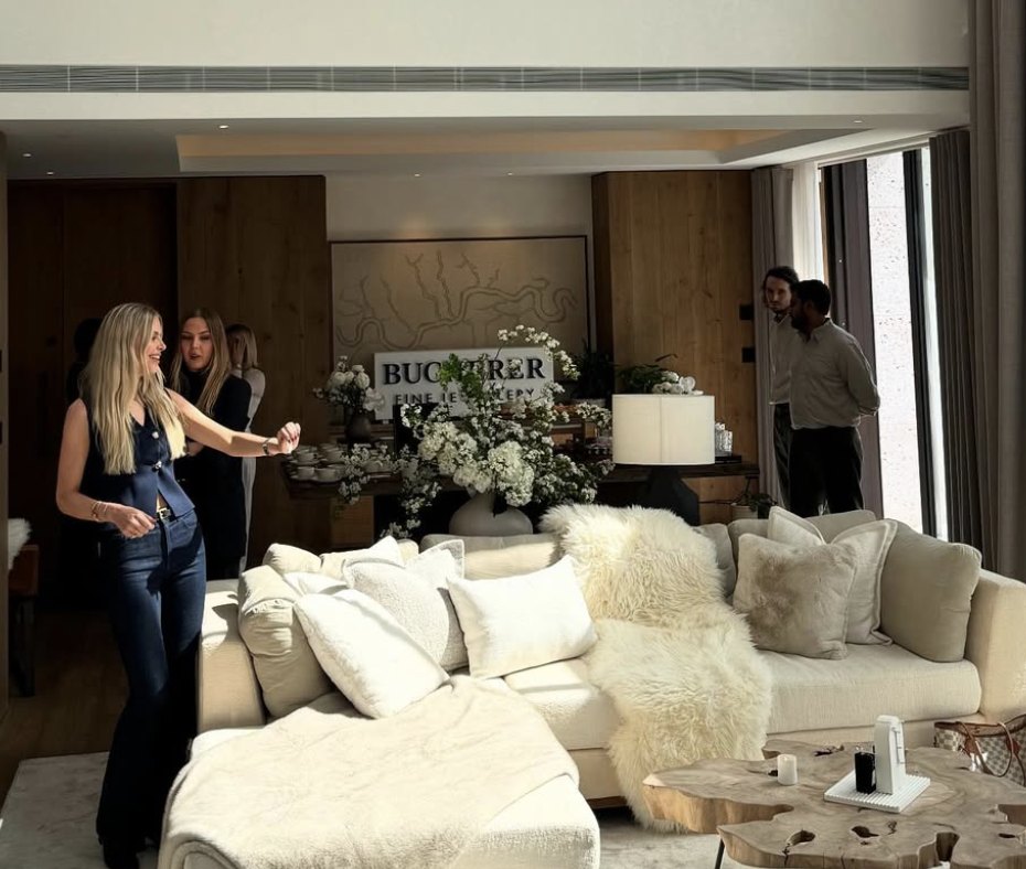 Guests in a bright lounge with cream sofas, white flowers and a Bucherer Fine Jewellery sign
